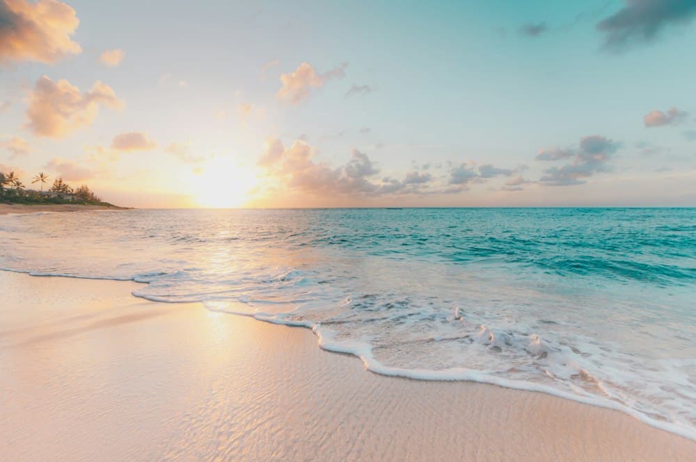 Sunset over a sandy beach with gentle waves