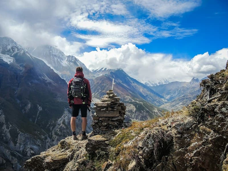 Trekker standing at a cairn above the Annapurna valley