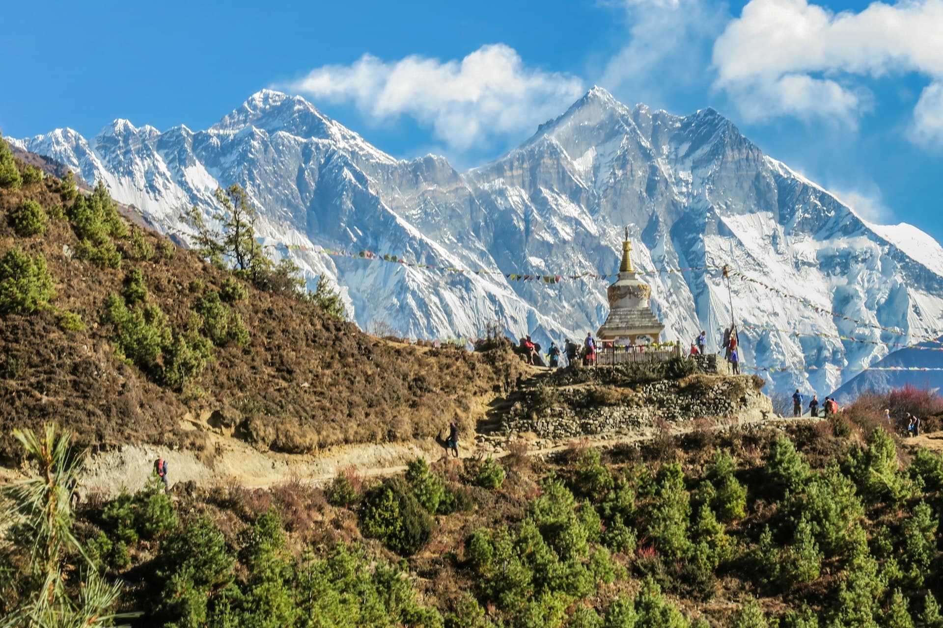 Himalayan peaks above a hillside trail and stupa in Nepal